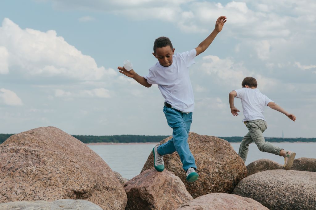 Two boys on rocks moving in opposite directions