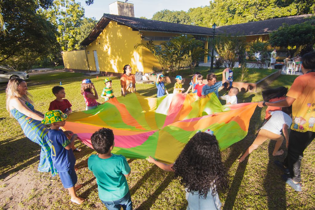 A group of kids holding a parachute at camp