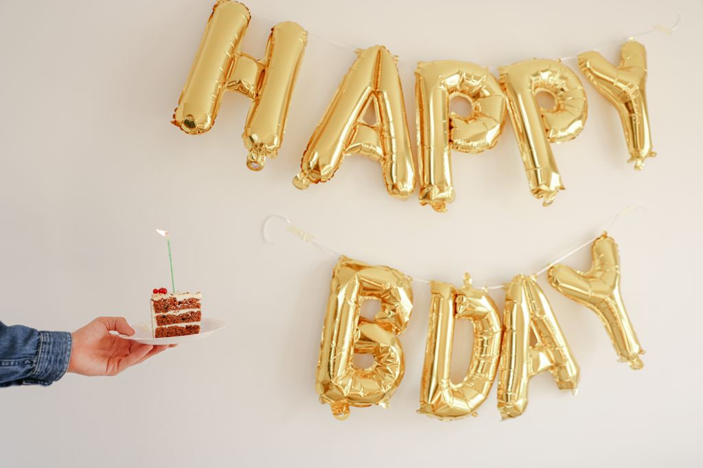 Happy BDY letter balloons and a piece of cake