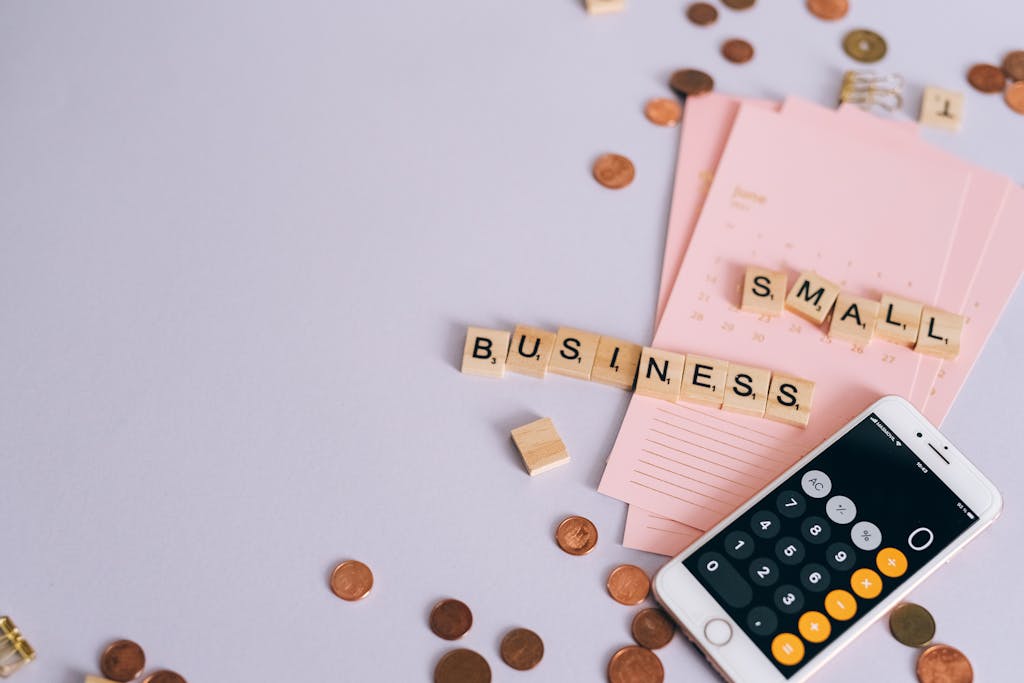 Scrabble tiles that say Small Business a calculator and pennies
